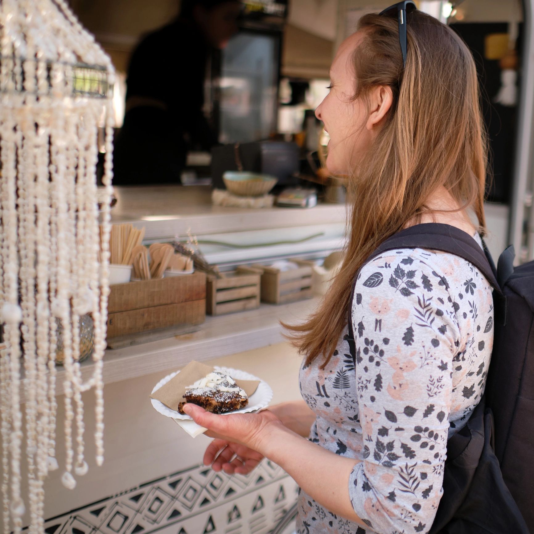 Customer purchasing a cake at a café counter, candid moment.