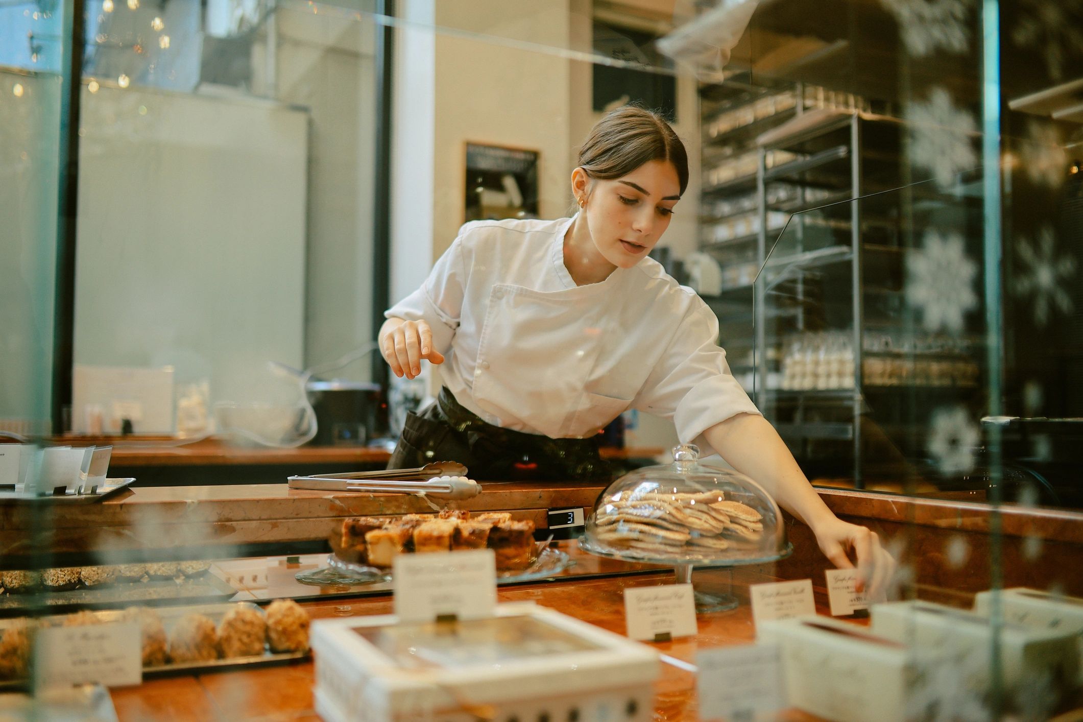 Baker arranging pastries in a bright bakery