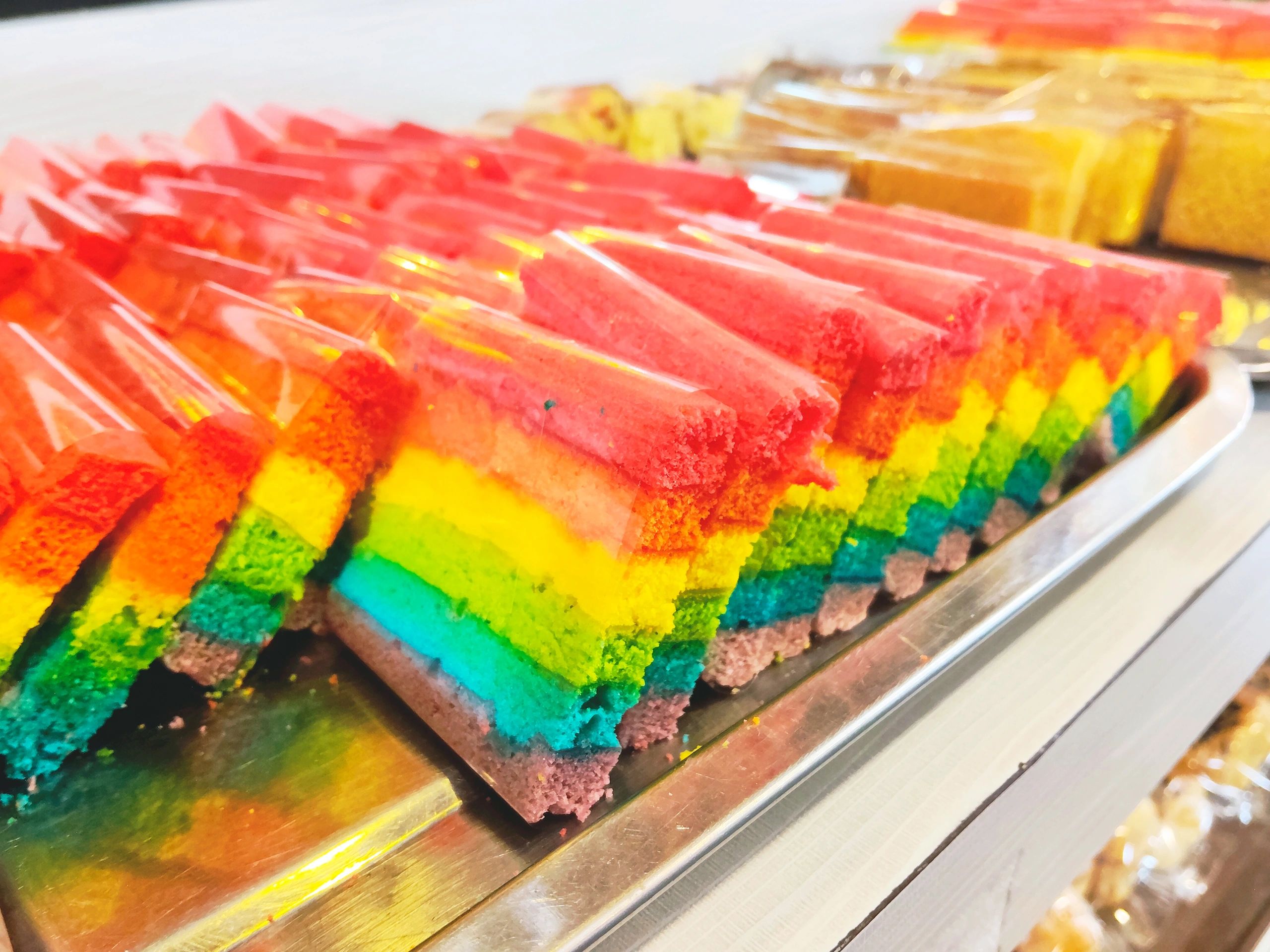 Colorful layered celebration cake slices arranged on a tray.